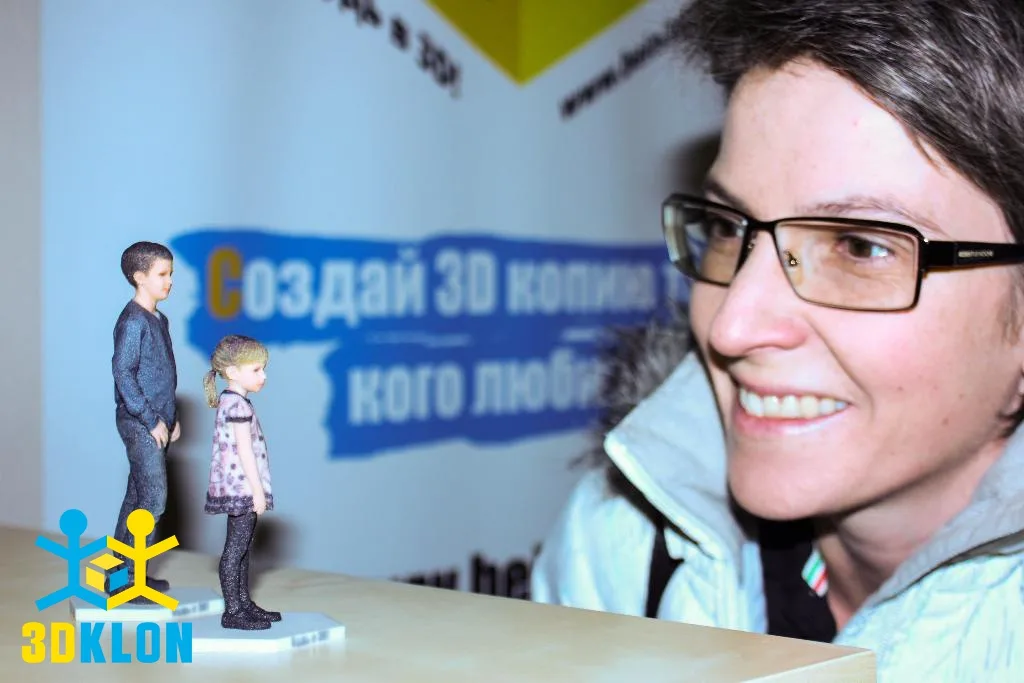 Женщина в очках рассматривает цветные 3D-фигурки мальчика и девочки
