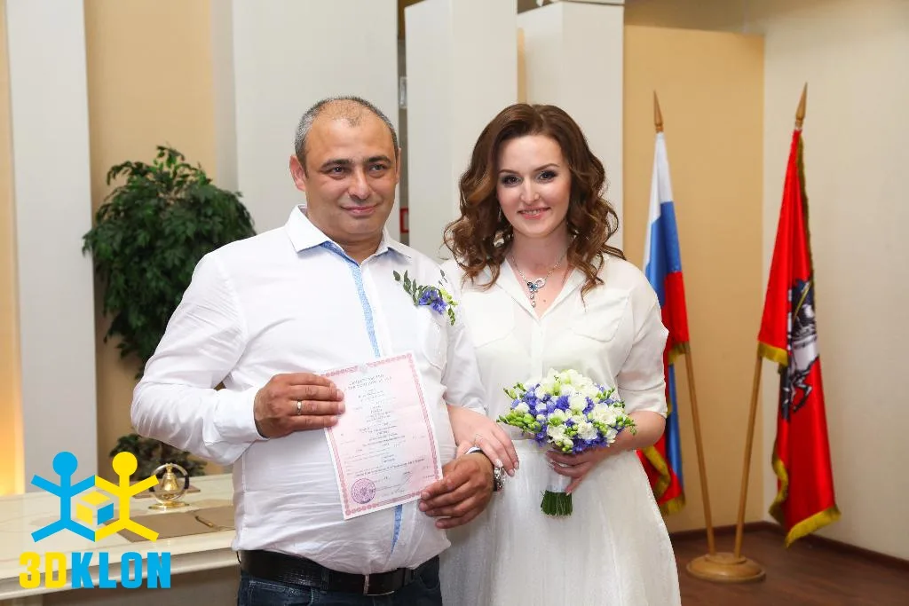Жених и невеста со свидетельством о браке и свадебным букетом в ЗАГСе
