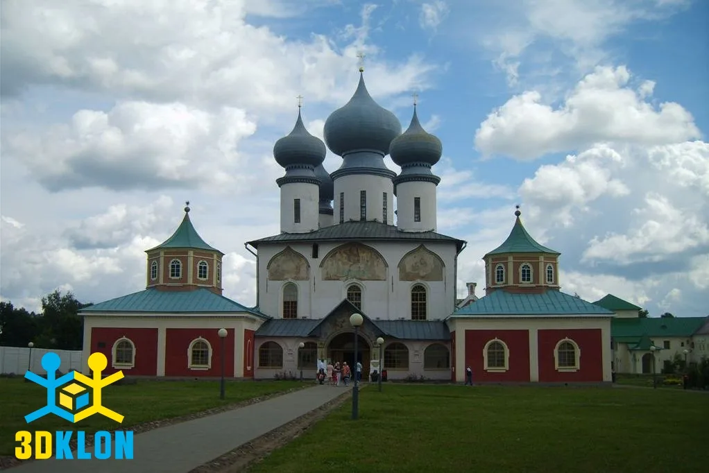 Православный каменный собор с куполами и пристройками на фоне облачного неба